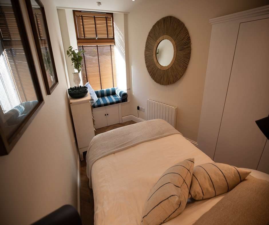 Remodeled holiday let bedroom with a neatly made bed and framed artwork on the wall above the headboard.