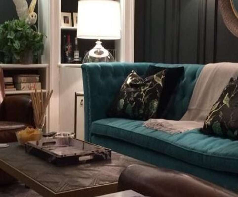 Modern residential living room with a gray and white couch, chair, coffee table, white walls, and a large window letting in natural light.