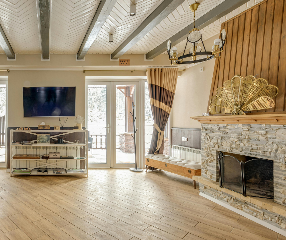 Rustic country-style living room by Decodence Design featuring wooden beams, cozy textiles, and neutral tones.